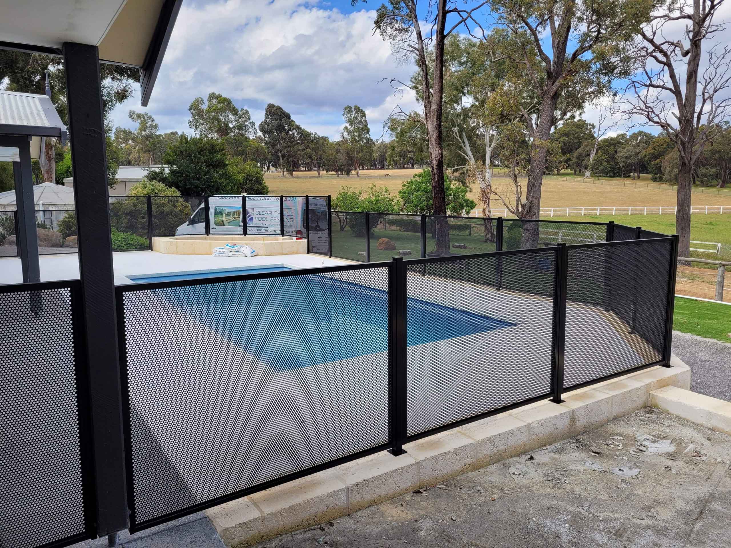 A pool with a perforated pool fence in the country