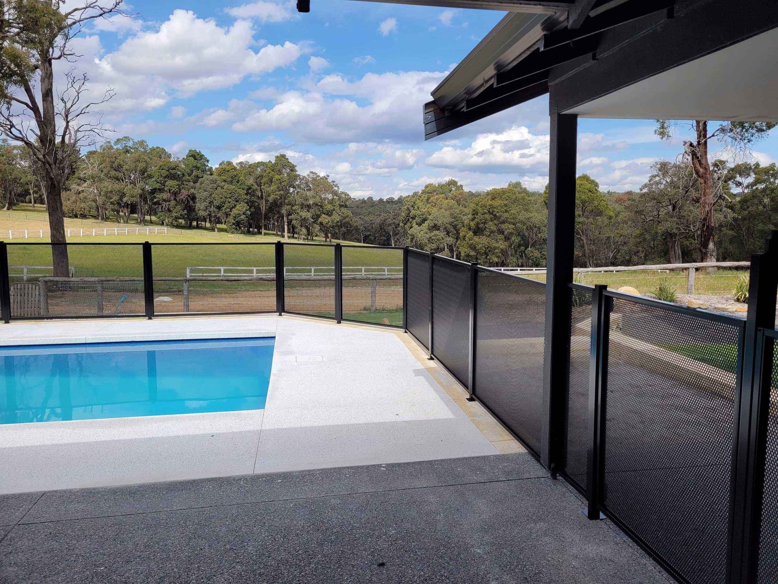 Perforated pool fencing around a pool in the country