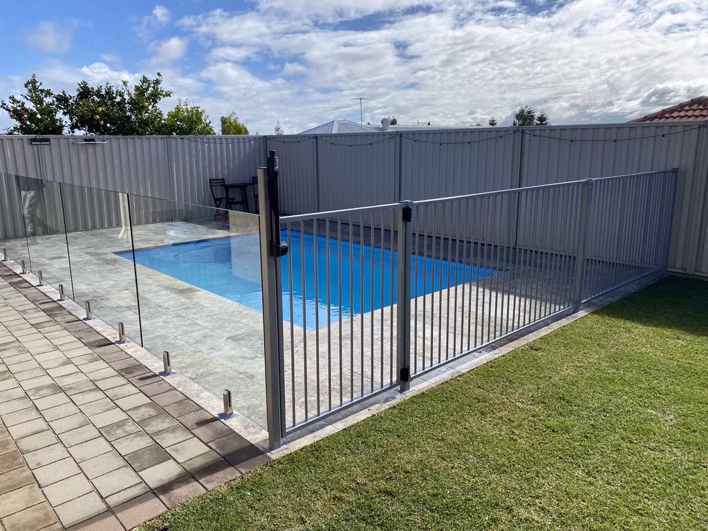 A combination of white slimline and frameless glass fencing around a rectangular pool