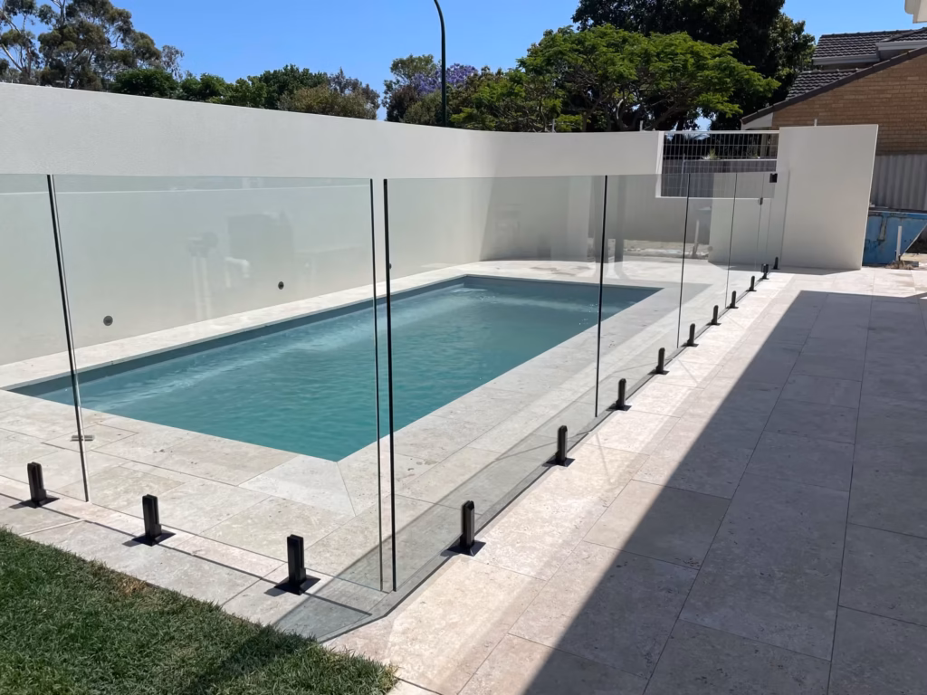 Frameless glass fence surrounding a rectangular pool
