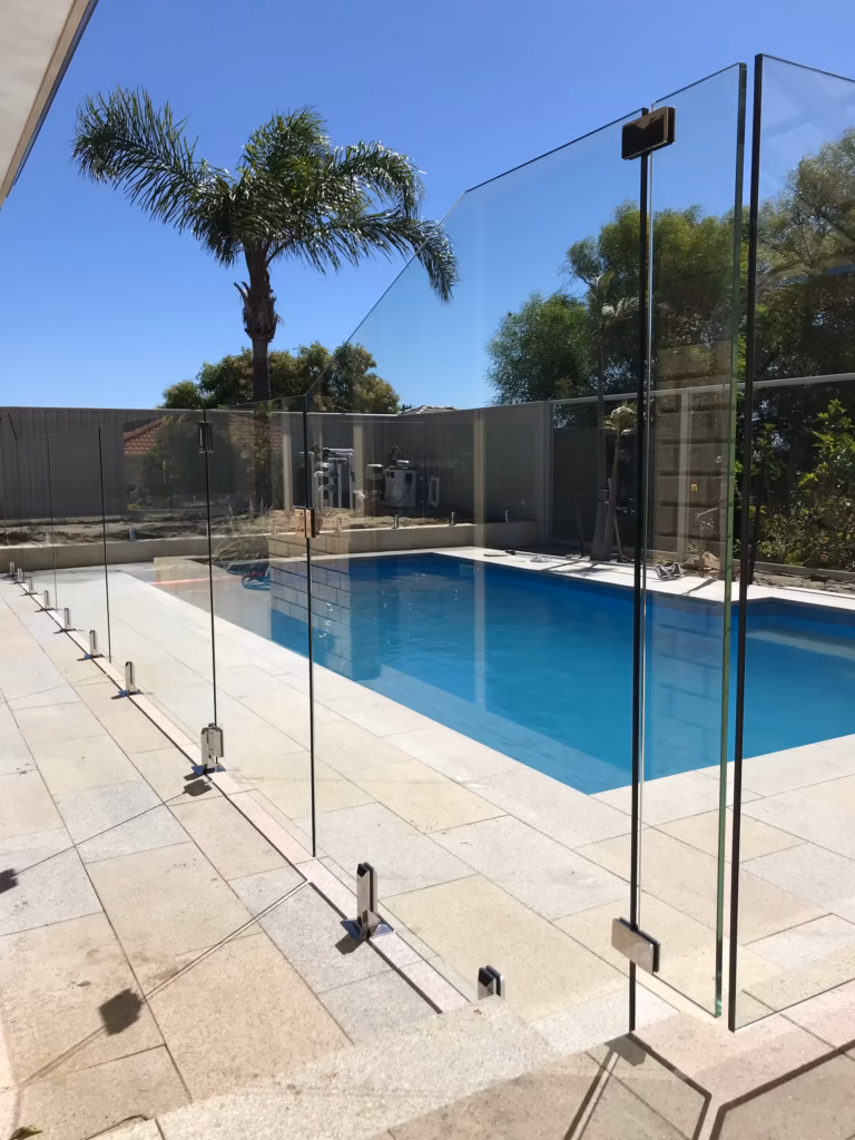 frameless glass site surrounding a blue rectangular pool