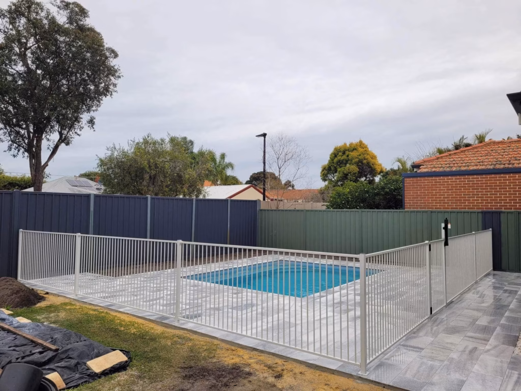 White tubular fencing around a small square pool